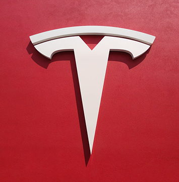 Streetwise IR business news on Tesla (image of Tesla logo on red background).