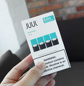 Image of hand holding Juul product box.
