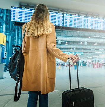 Image of woman with travel suitcase at airport.